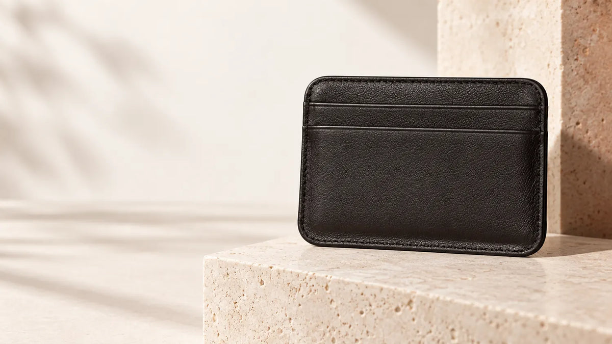 The Essential Wallet standing on a travertine ledge in soft daylight